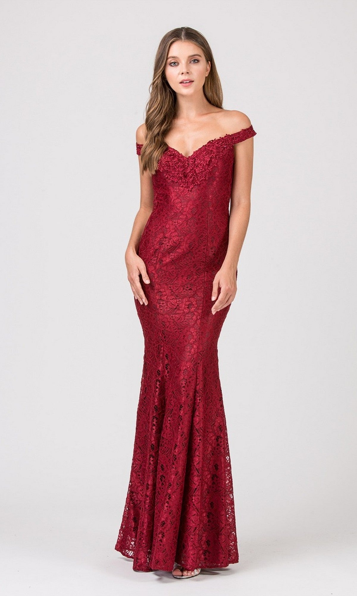 A woman wearing the Eureka 8030 long prom dress—a floor-length, fitted burgundy gown—stands elegantly against a plain light background.